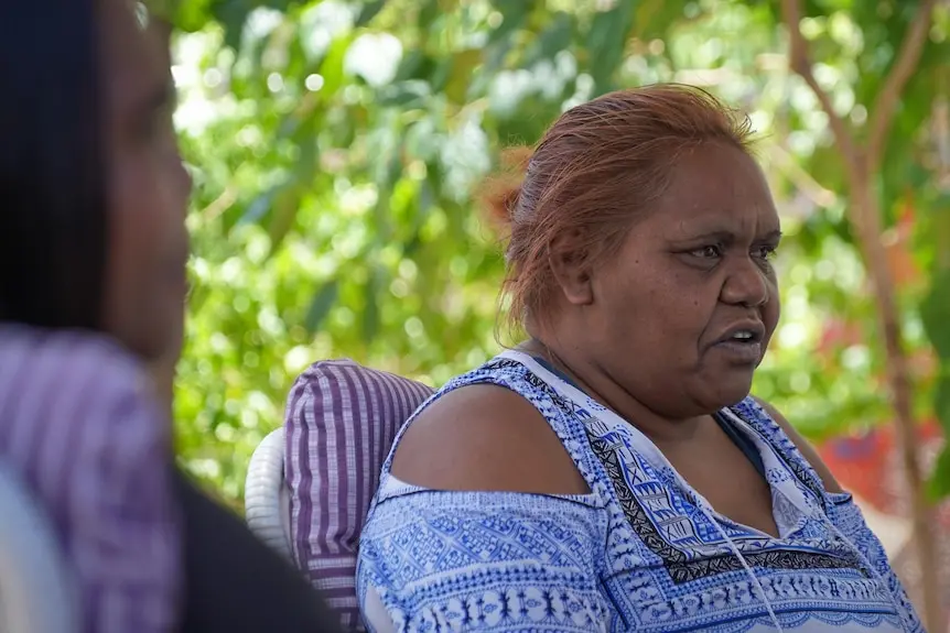 An Aboriginal woman in front of a tree