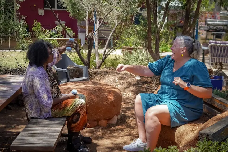 Two women work out in a backyard