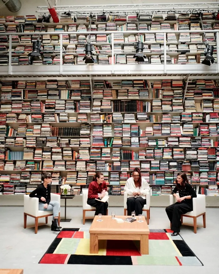 Four people seated in front of a wall of books