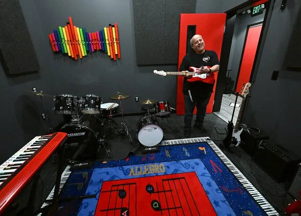 Chuck Silber, co-owner of School of Rock in Loveland and Fort Collins, shows some of the smaller instruments for younger students Tuesday, Feb. 20, 2024, at their new location in Loveland. (Jenny Sparks/Loveland Reporter-Herald)