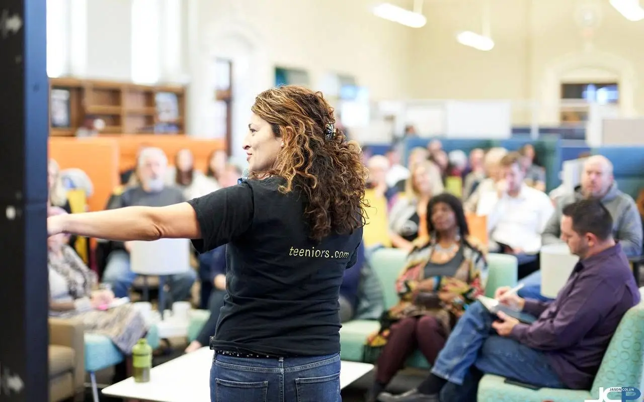 A woman speaking in front of a crowd. Next Avenue, digital buddy, social connection