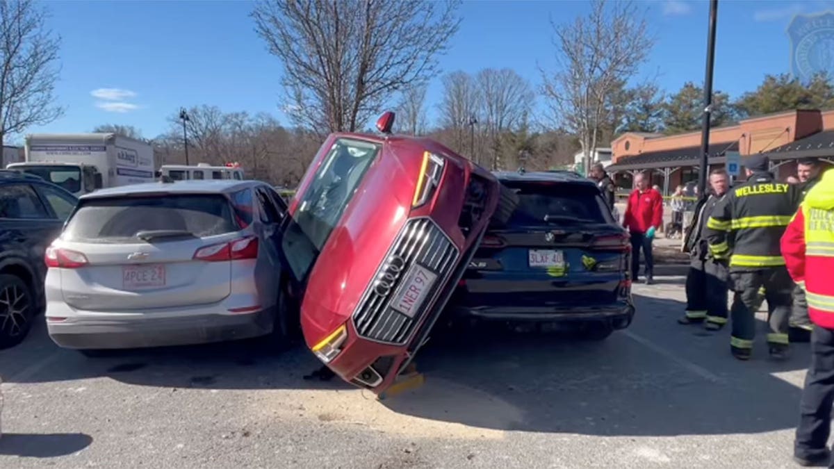 Driver rescued after car wedged between two vehicles in parking lot crash