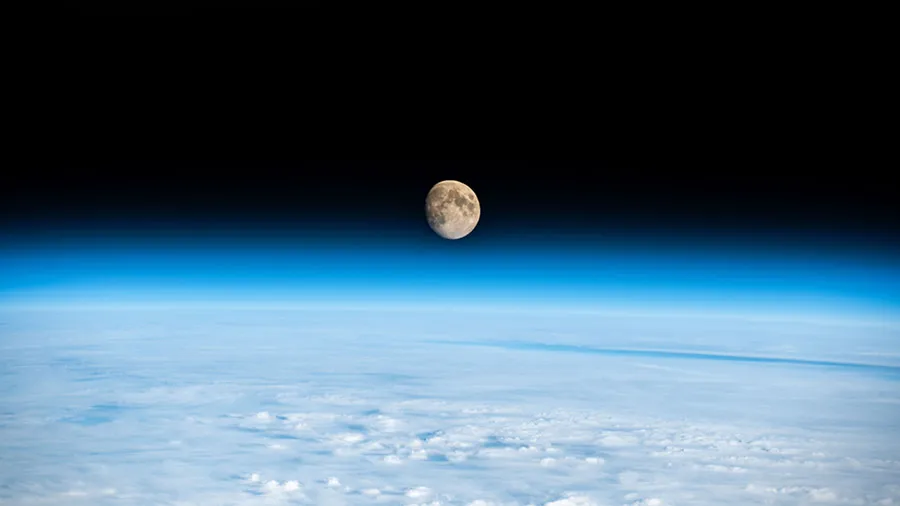 The waxing gibbous Moon is pictured above the Earth's horizon in this photograph from the space station as it orbited above a cloudy Western Europe.