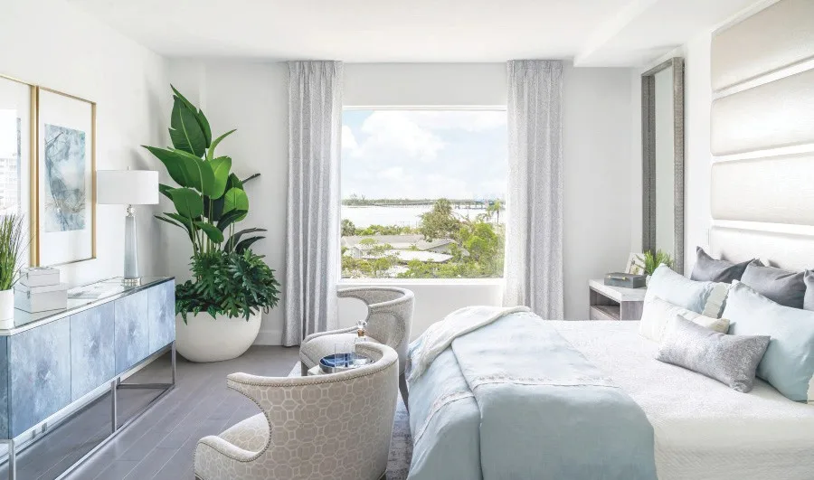 The master bedroom of Grandview’s Residence 301 model designed by Clive Daniel Home provides a serene retreat in a private wing featuring white and watercolor blues with stunning views of Estero Bay.