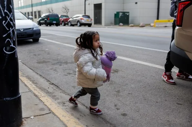 Antonella Sanchez, 2, from Venezuela, holds a stuffed toy before leaving with her family from their Lower West Side shelter, Feb. 13, 2024 in Chicago. (Armando L. Sanchez/Chicago Tribune)