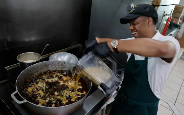 Chef Travis Reece of Chef Reece Kitchen in Pembroke Pines pours a spice mixture into a pot of simmering oxtail stew, Thursday, Feb. 15, 2024. Black culinary excellence will be celebrated at five newish events during next week's 2024 South Beach Wine and Food Festival, returning Feb. 22-25 with a smorgasbord of 110 events across Miami-Dade and Broward counties. (Joe Cavaretta/South Florida Sun Sentinel)