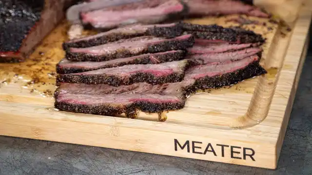 cutting board with meat sliced on top