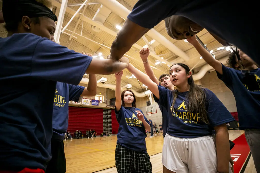 Coach Solomon Yearby leads kids in a quick cheer after defense drills at Rise Above Basketball's clinic at the University of Denver. Jan. 28, 2024.