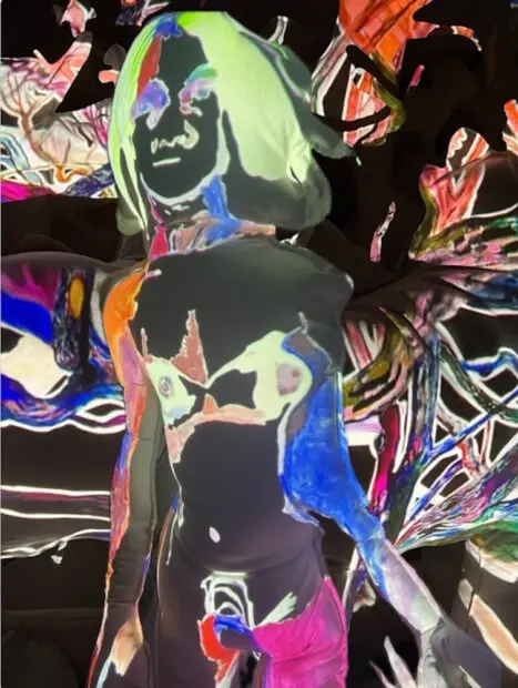 A photograph of a projection on a soft sculpture of a female figure by Elizabeth Chapin.