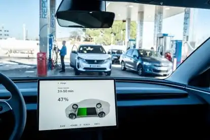 The interior of an electric car at a gas station.