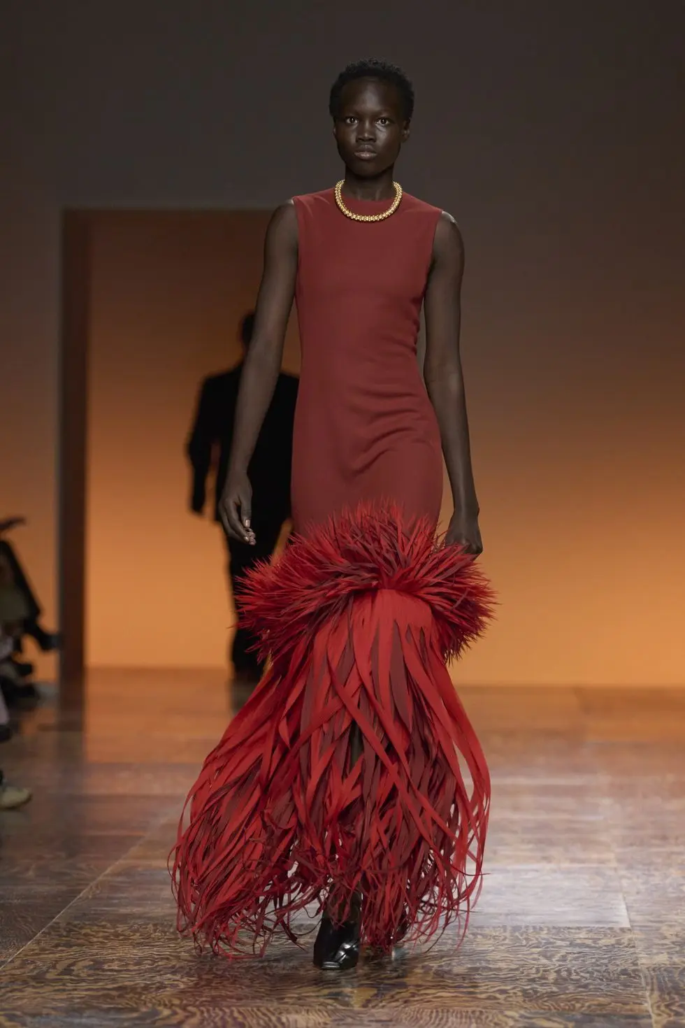 a person wearing a red dress and a black skirt