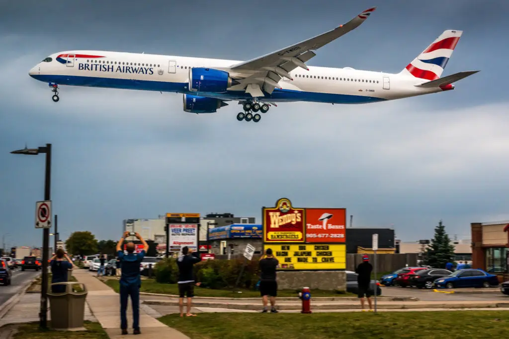 a large airplane flying over a runway