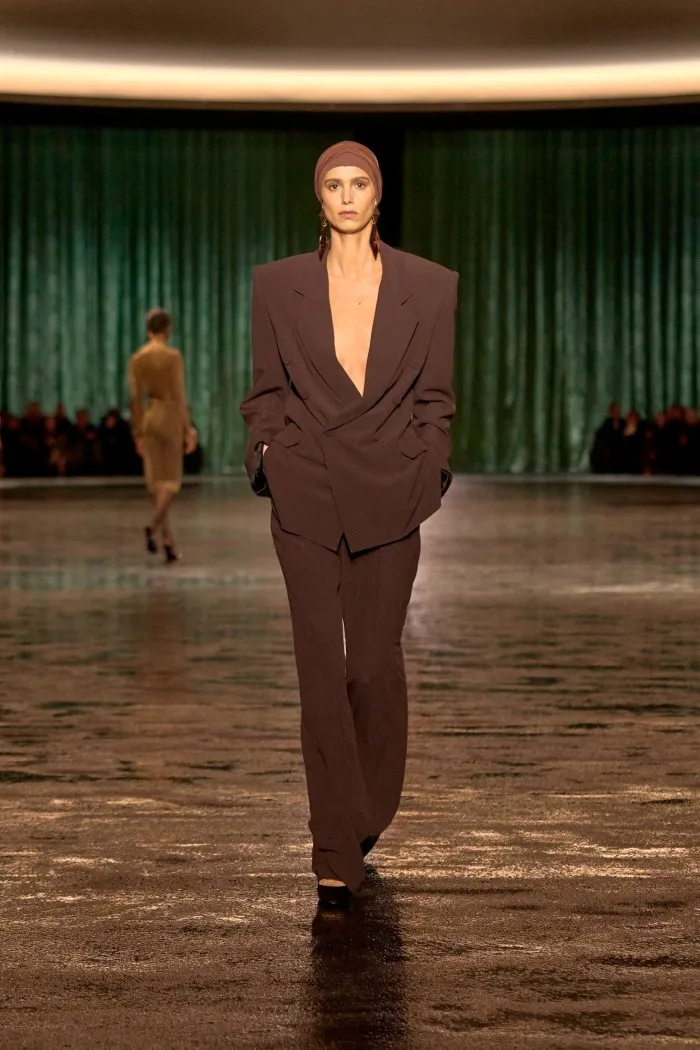 A model wears an oversized brown jacket and trousers