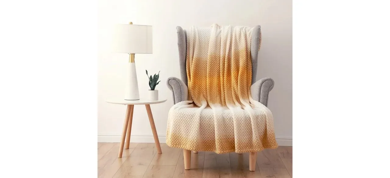 Mainstays Ombre Velvet Plush Yellow Throw draped over chair