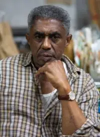 man looking at the camera with bent elbow up to chin
