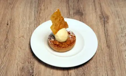 an individual treacle tart with a scoop of ice cream 