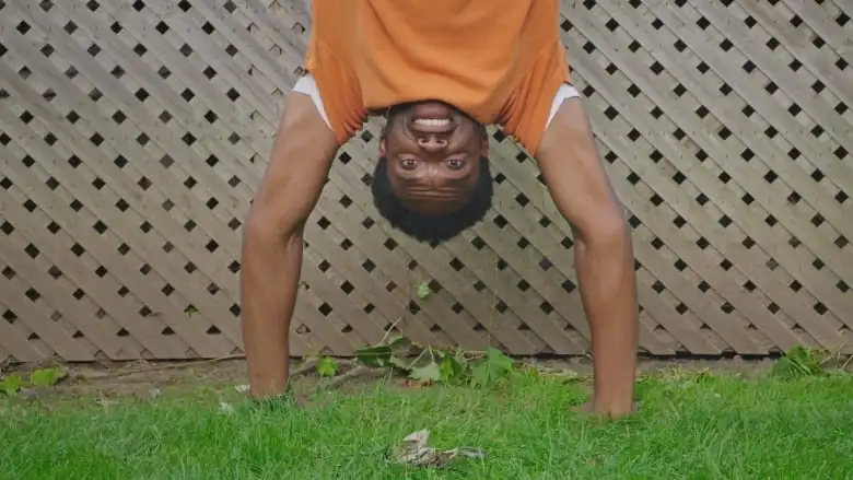 Anthony Morgan poses upside-down while performing a handstand.