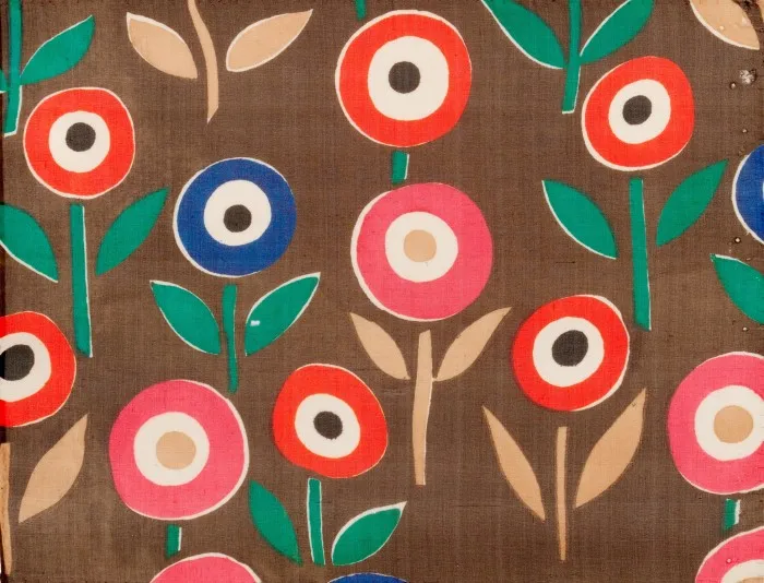 Textile collage of flowers with green and orange stalks and red and blue circular heads