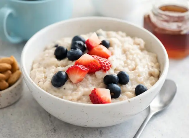 bowl of oatmeal topped with strawberries and blueberries