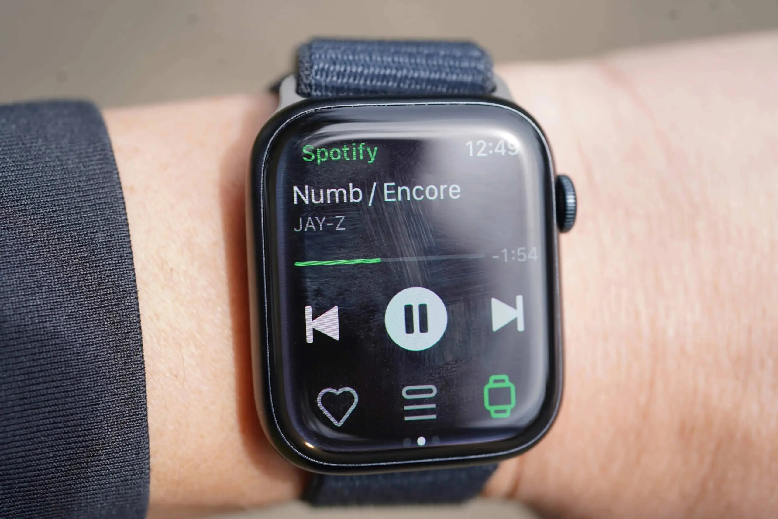 a person wearing an apple watch with the spotify app open