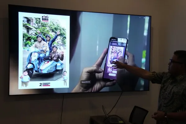 Noudhy Valdryno, the digital coordinator for the campaign team of Indonesian presidential frontrunner Prabowo Subianto, shows the interface of a web application that allows supporters to upload photos to make AI-generated images of them with Subianto, in Jakarta, Indonesia, Wednesday, Feb. 21, 2024. (AP Photo/Dita Alangkara)