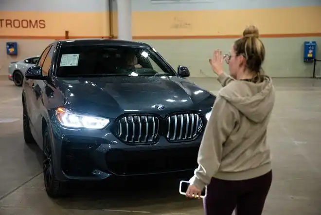 Kendra Aukamp directs traffice as new vehicles arrive at the events center for the All Iowa Auto Show Thursday, March 14, 2024, at the Iowa Events Center.