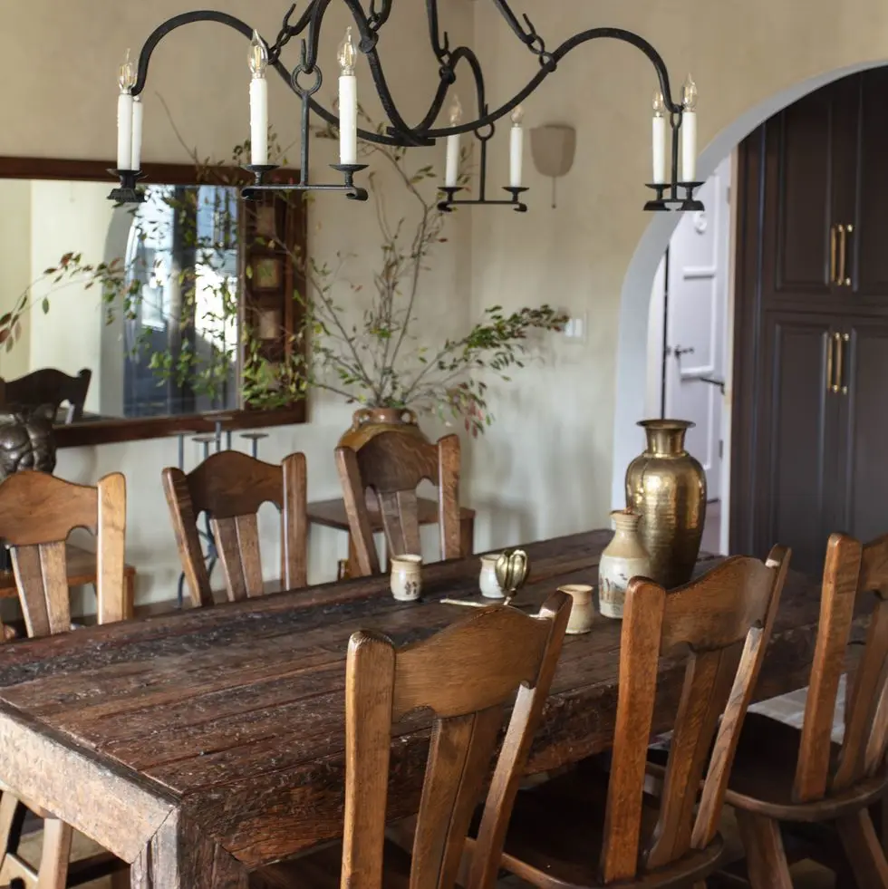 a dining table with a vase and candles on it