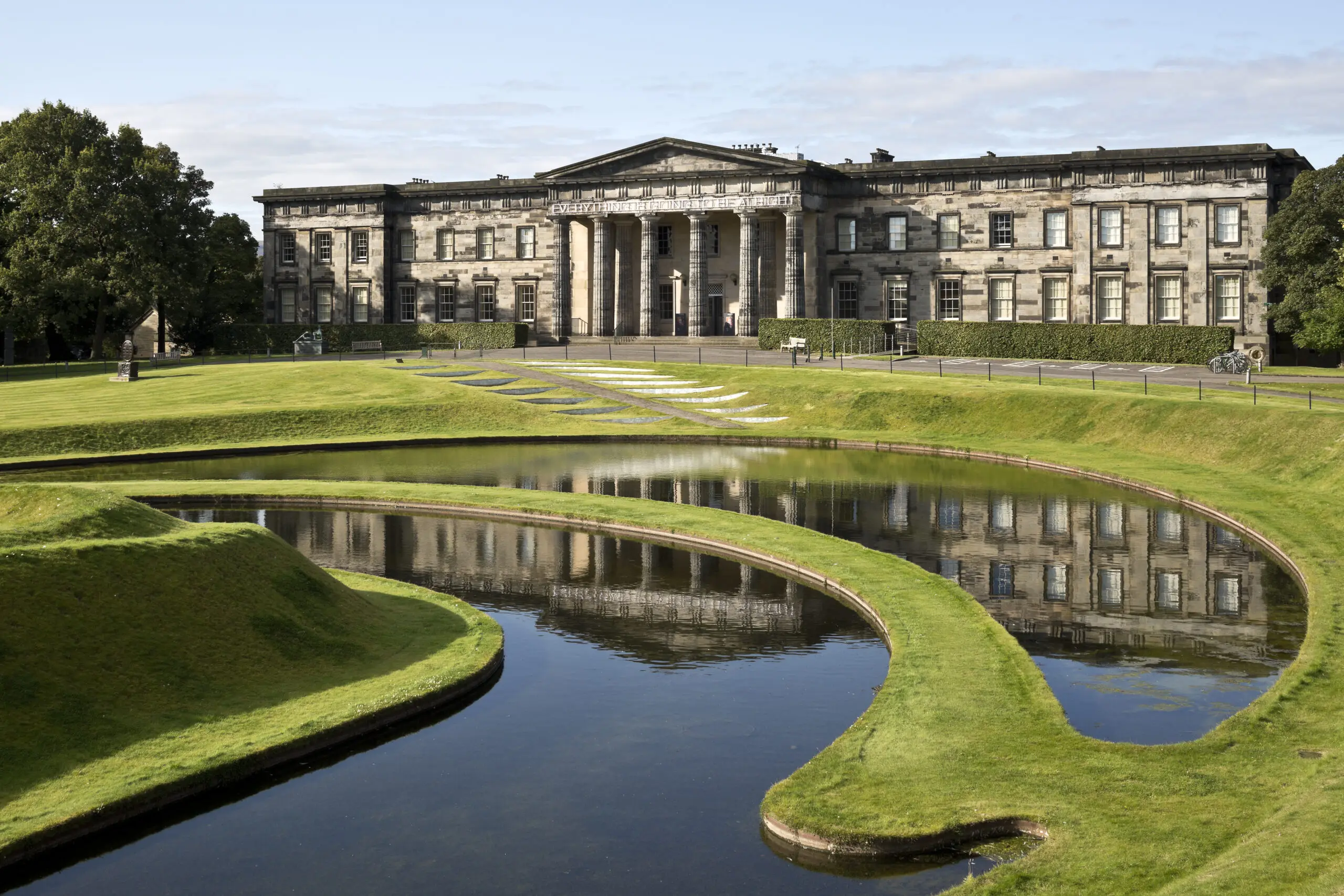A mansion-like building set in a sprawling lawn