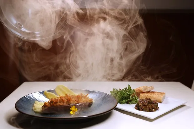 The eggplant course (mirza ghasemi and sabzi khordan) with smoke at Maman Zari restaurant in Chicago's Albany Park neighborhood is seen on Wednesday, March 13, 2024. (Terrence Antonio James/Chicago Tribune)