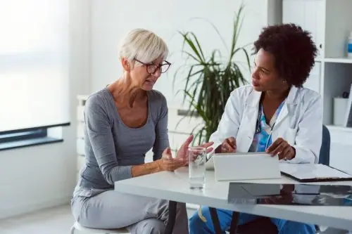 middle-aged woman talking to doctor