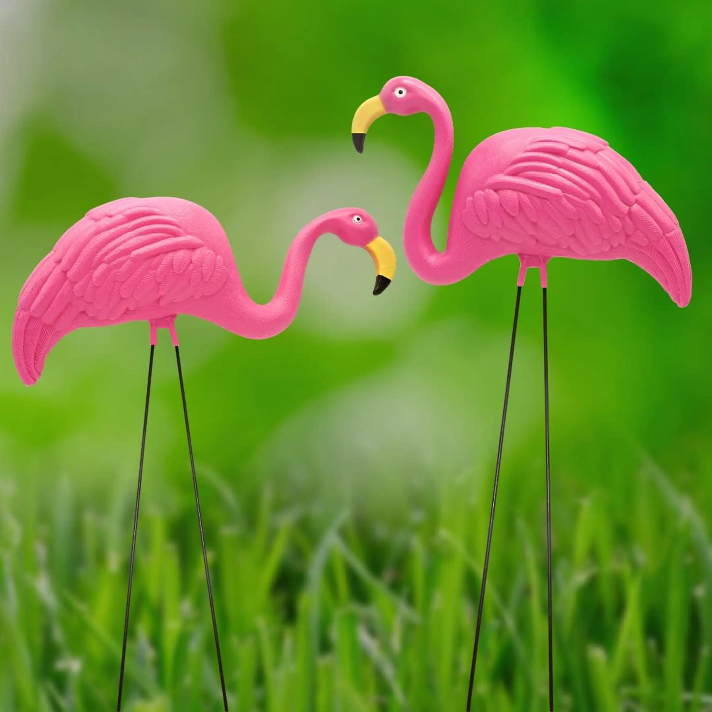 Two plastic pink flamingos on a green lawn.