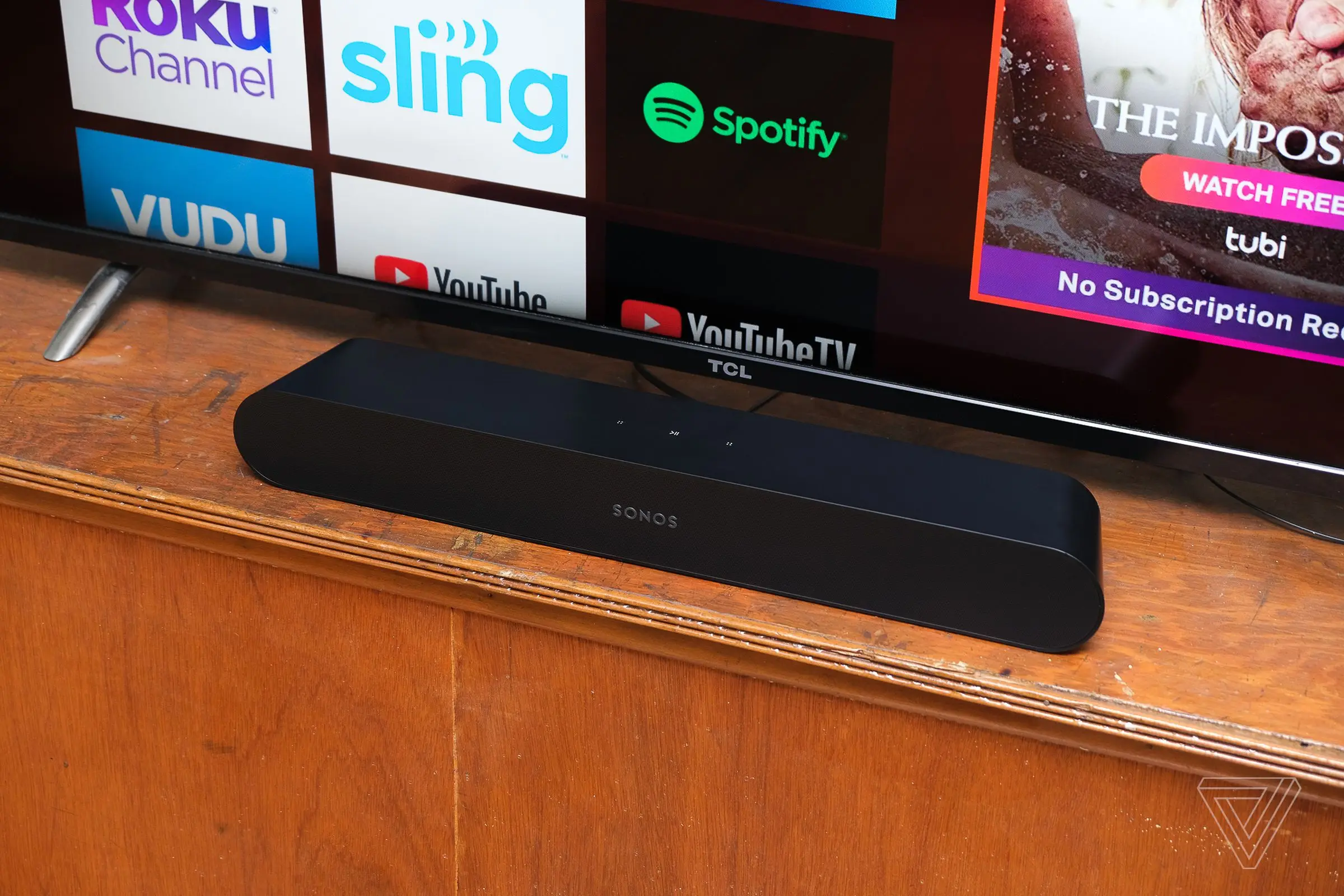 A photo of the Sonos Ray soundbar next to a TCL TV.