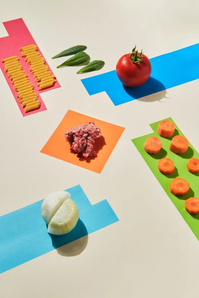 raw ingredients on yellow background to make macaroni bolognese recipe