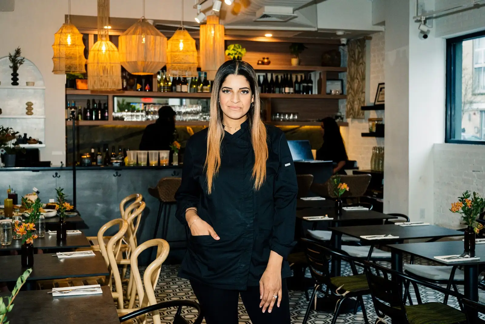 Yesenia Ramdass stands in the dining room at HAAM wearing all black.