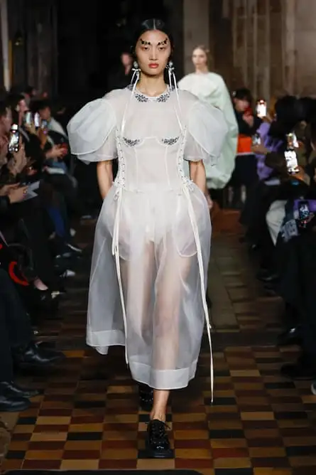 A model wearing a corset stitched into floaty, see-through white fabrics