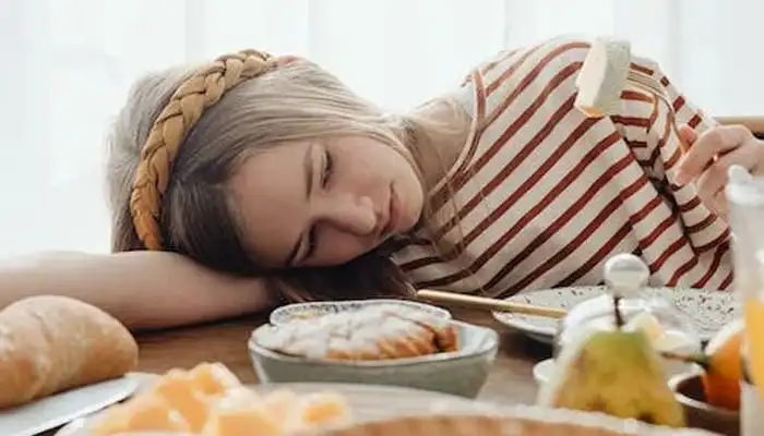 A young girl looking at a piece of bread. — Pexels