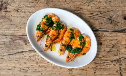 ‘Swimmimg through a lake of garlicky, parsley-rich butter’: grilled prawns.