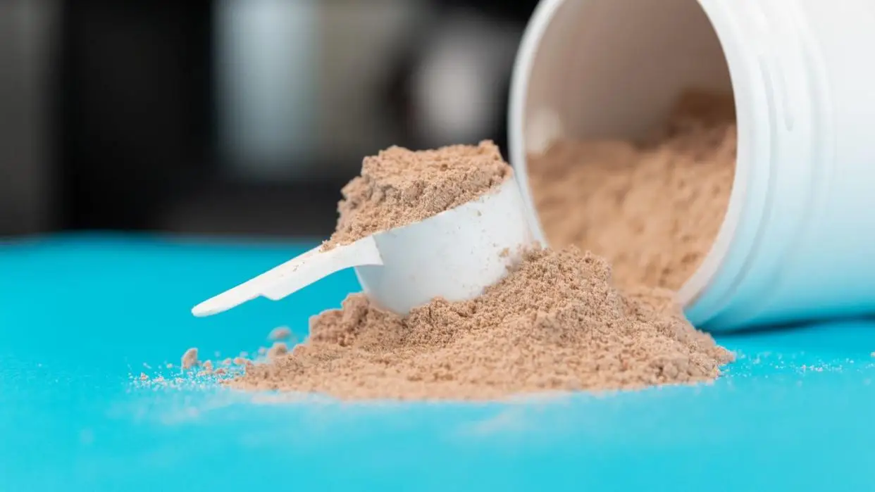 scoop filled with brown or chocolate flavored protein powder