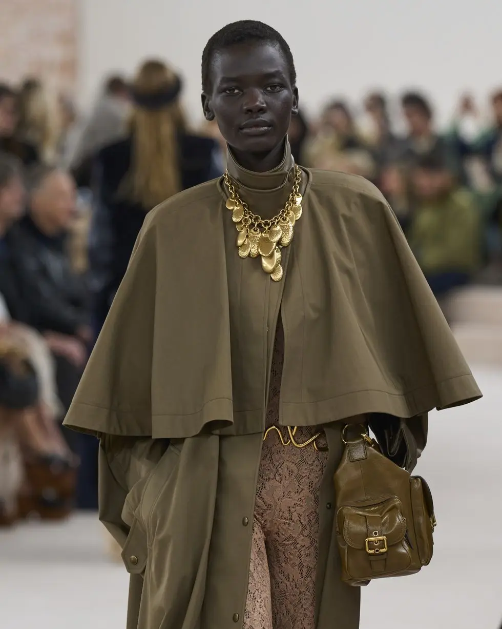 a woman wearing a gold necklace