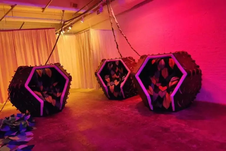 Relaxation pods in pink light at the installation at the Fabric Workshop