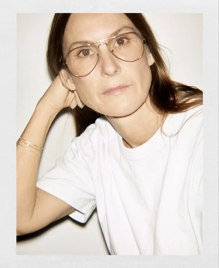 Fashion designer Louise Trotter wearing a white t-shirt and round glasses