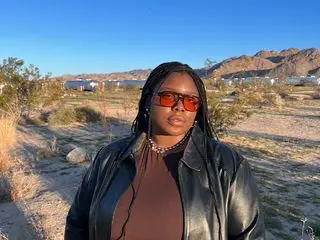 Chichi wears brown skirt and tank set with leather jacket and aviator sunglasses in the desert