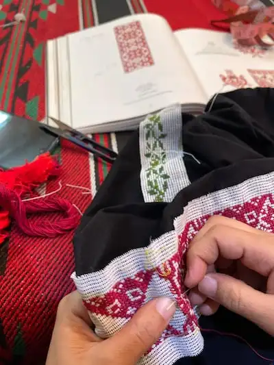 An artisan in Gaza stitching the tatreez for Ajdadi Collective. Photo: Zak Jarallah