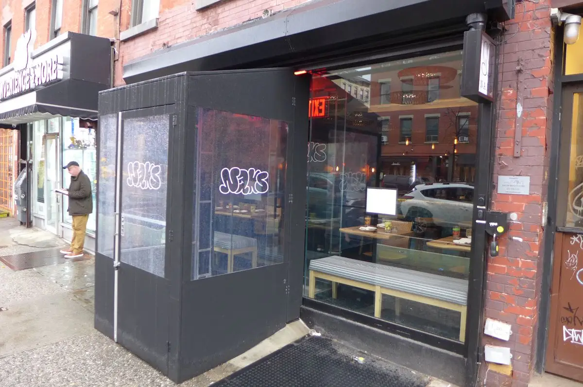 A dark storefront with a black canvas entrance.