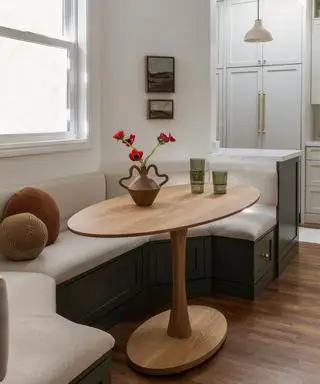 banquette with wooden table and vase and flowers