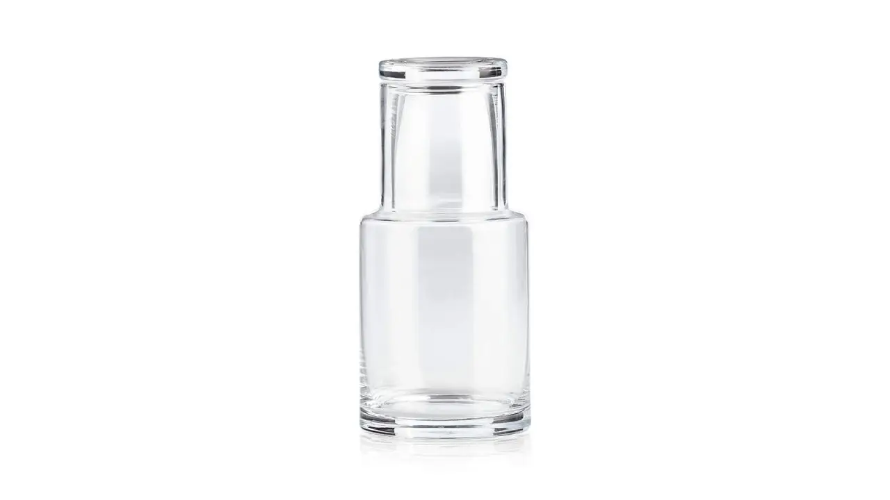 A clear glass carafe and its matching tumbler/lid on a white background.