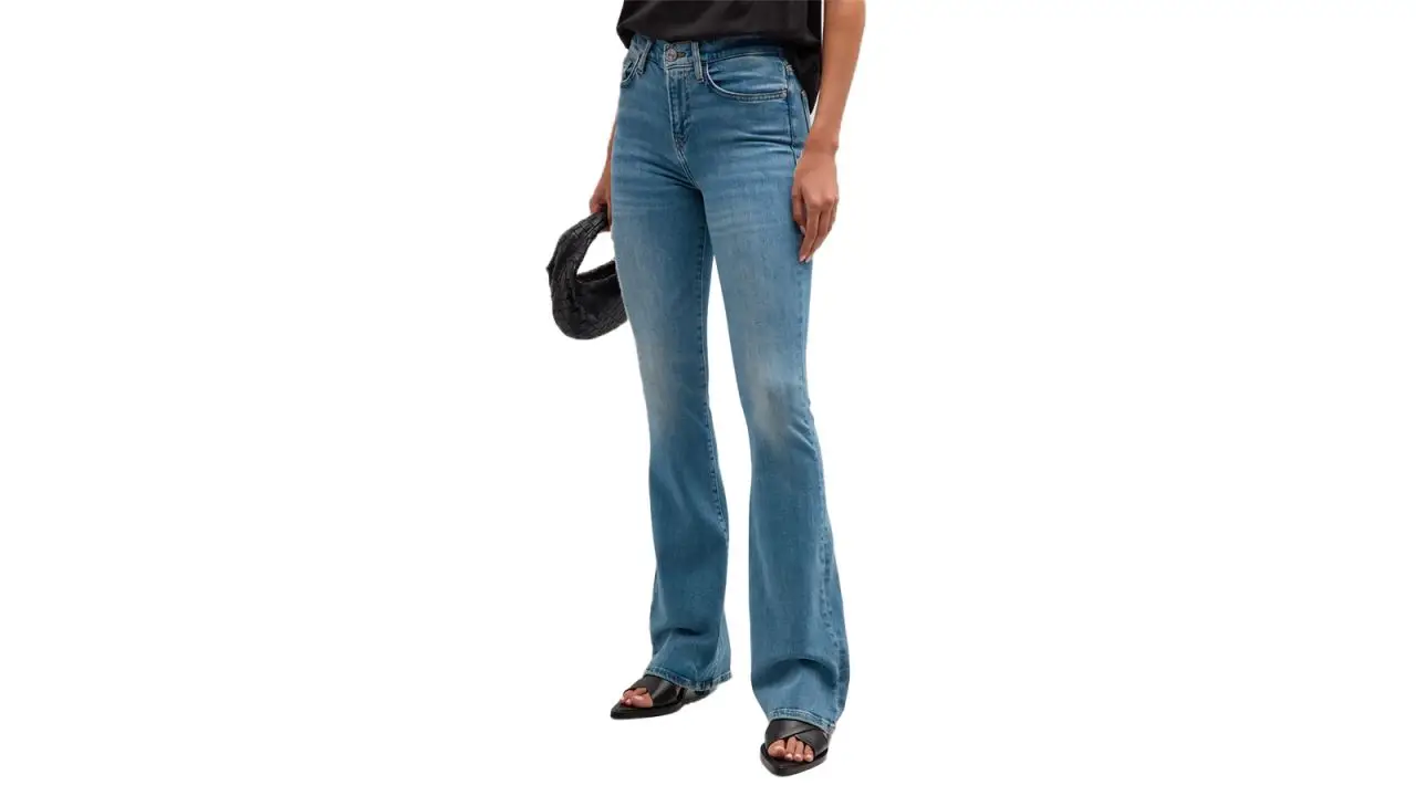 A person wearing Frame Le High Flare Light-Wash Denim Jeans on a white background.