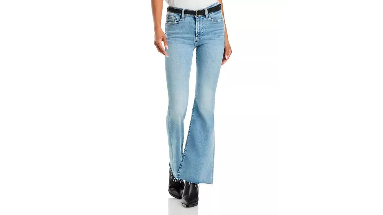 The legs of a person wearing Frame Le Easy Flare jeans in the Colorado color.