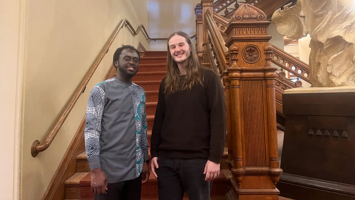 Two people standing in front of a staircase. 