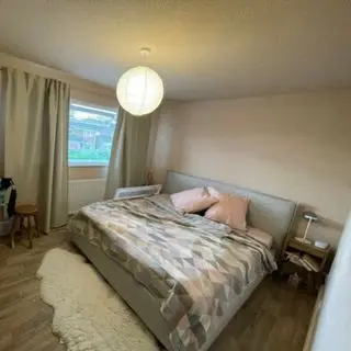 White painted bedroom with bed, bedside table, and lamp